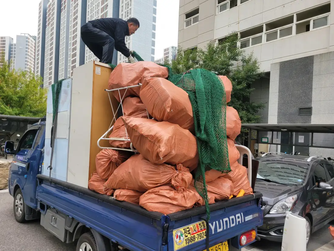 아파트 앞에서 포대와 가구를 트럭에 적재하는 작업