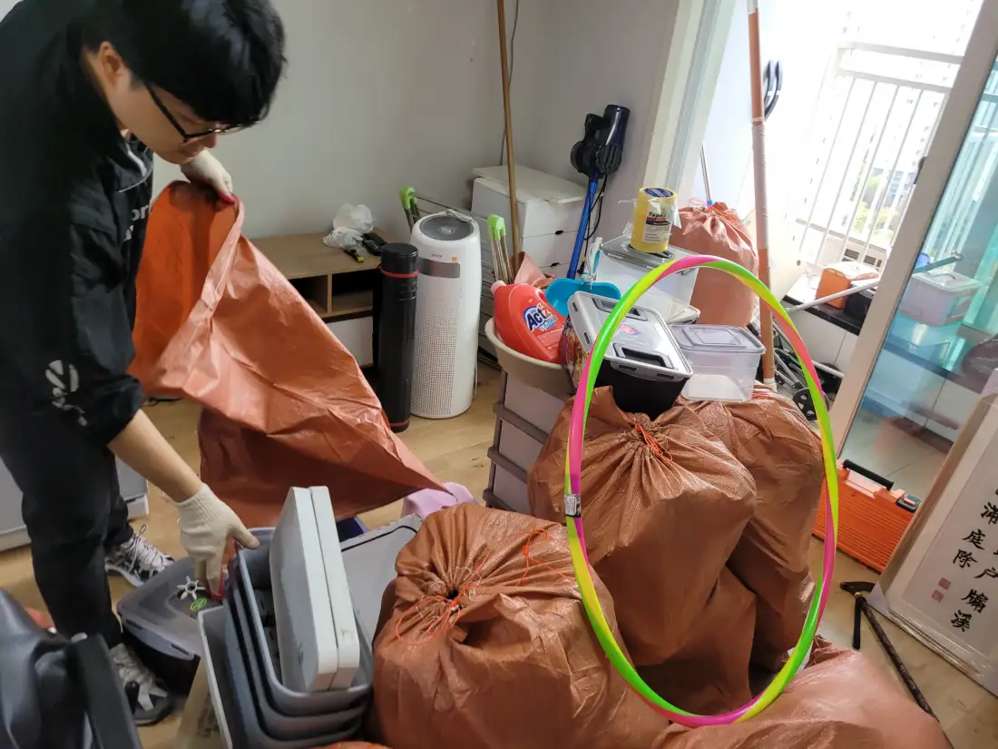 작업자들이 방 안에서 폐기물을 포대에 담아 정리하는 현장