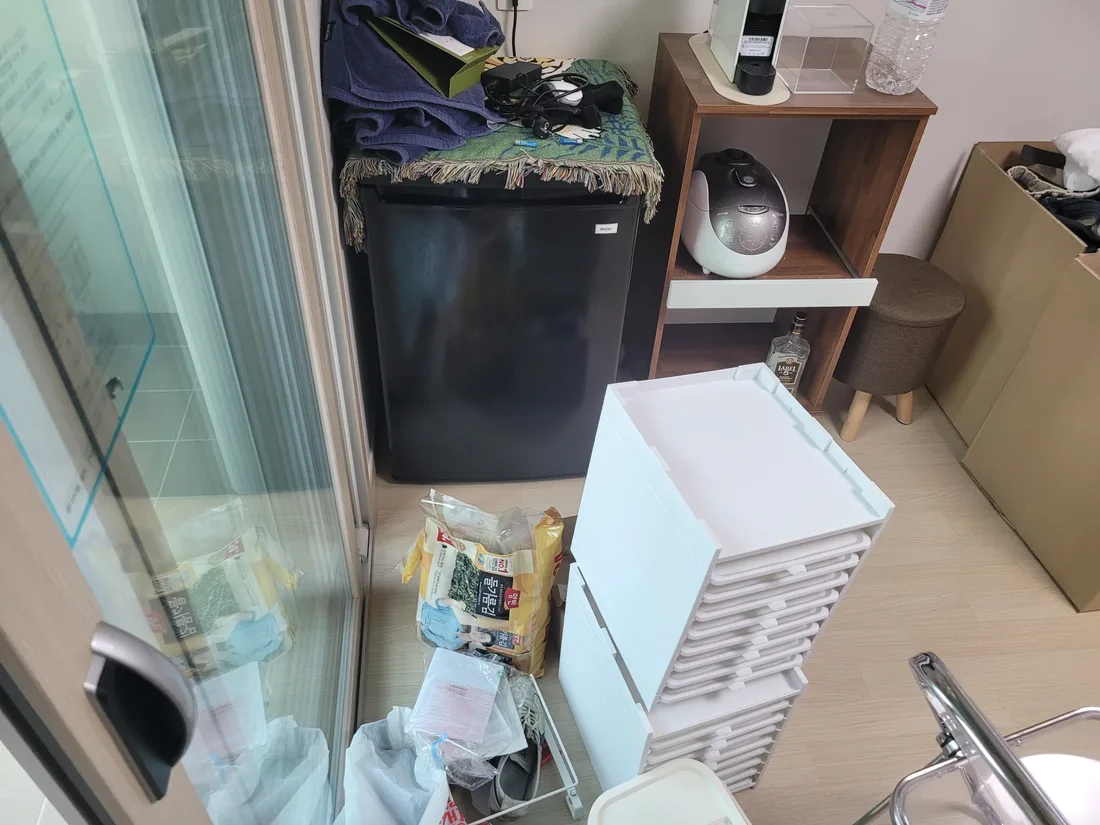 작은 냉장고와 수납함이 있는 방