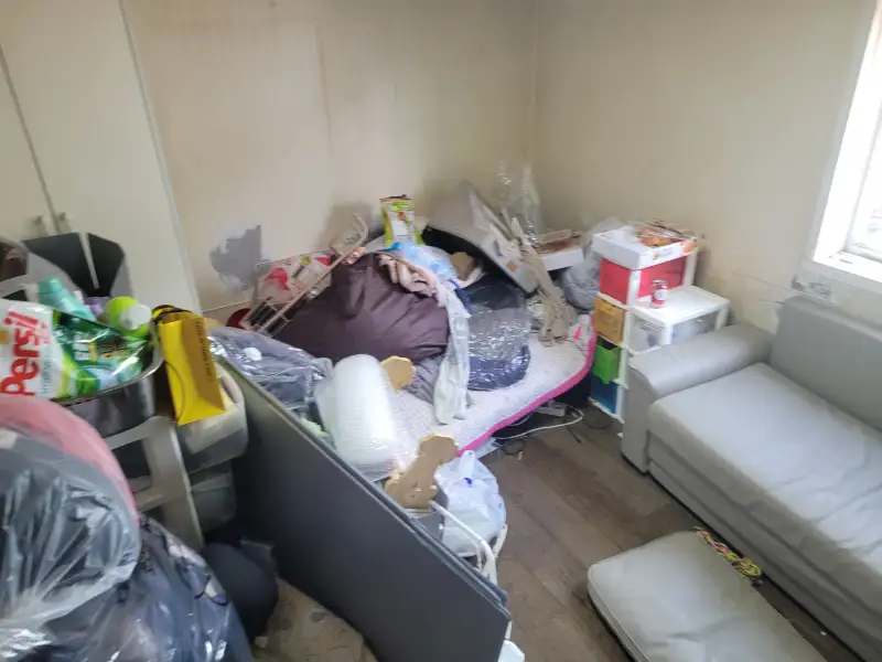침대 위와 주변에 물건이 쌓인 원룸