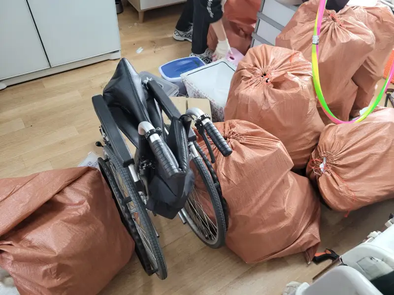 휠체어와 폐기물 포대가 놓인 방 내부