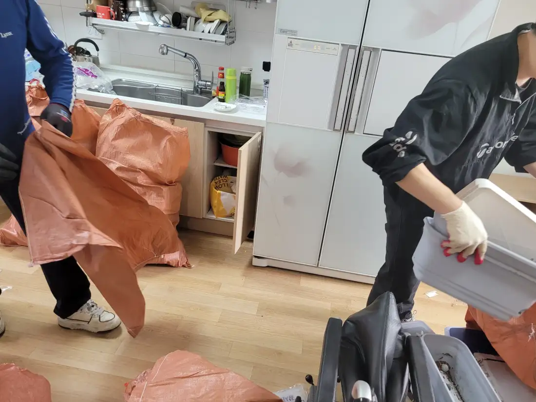 주방 앞에서 작업자가 폐기물 포대를 다루는 모습