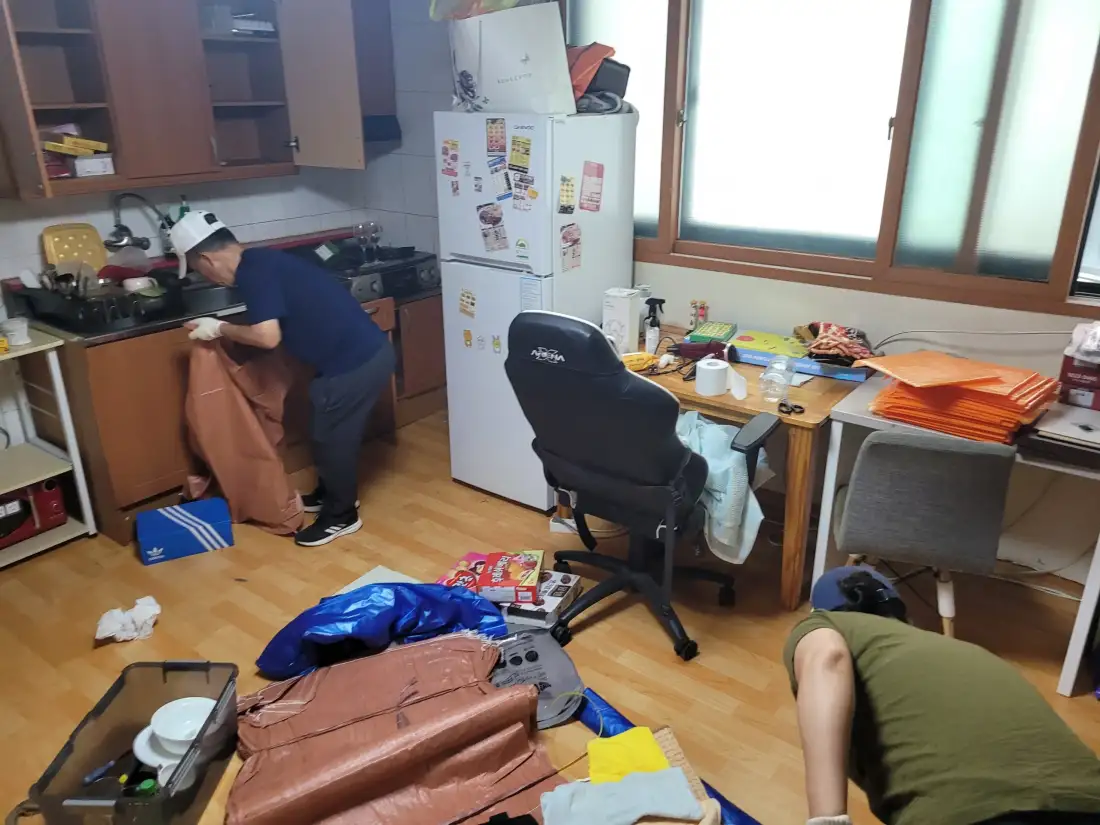 원룸에서 작업자가 물건을 분류하고 포대에 담는 현장